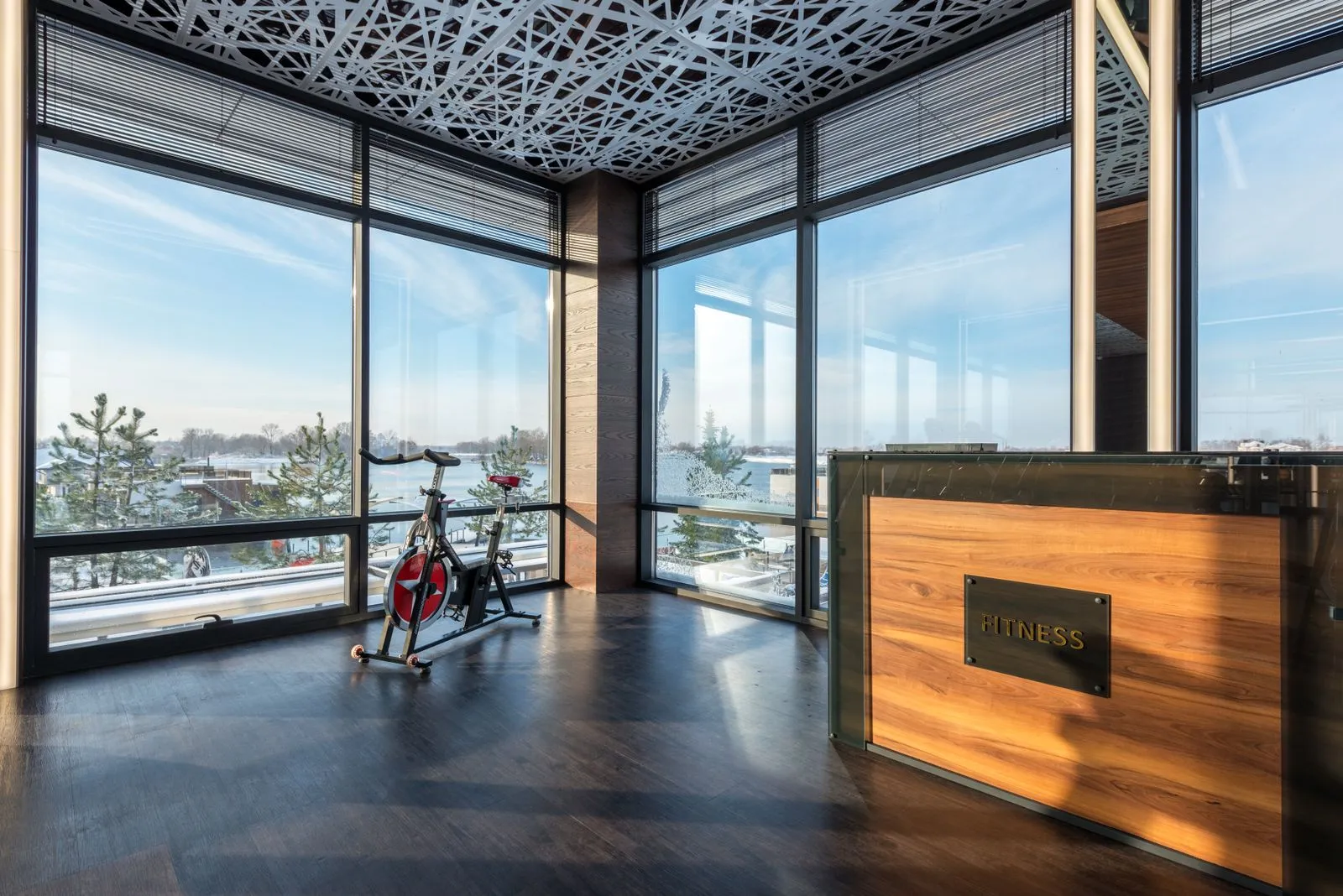 A bright, modern gym reception area with floor-to-ceiling windows and a water view